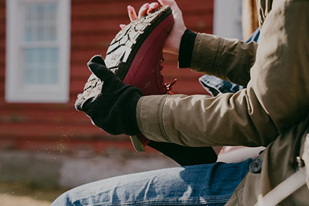 Person, die einen Stiefel auszieht
