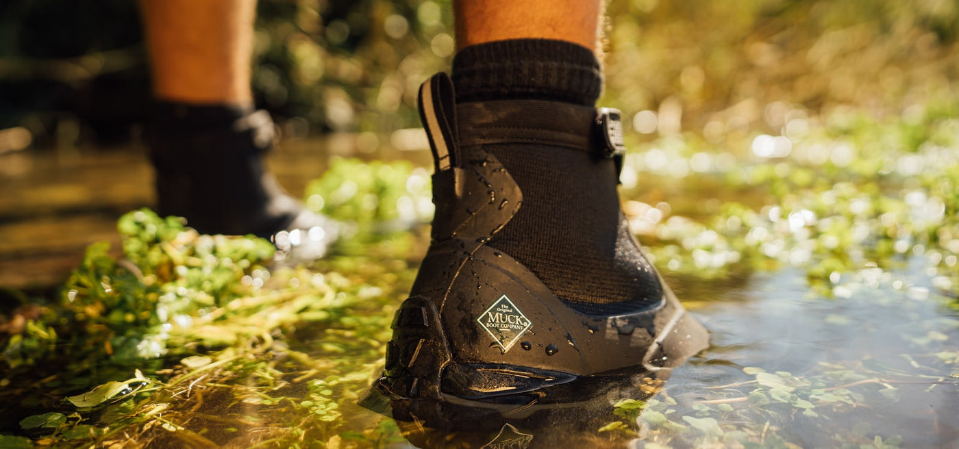 Close-up image of a pair of Muck Boots Apex boots in water